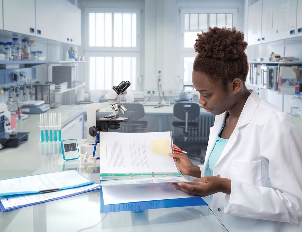 Laboratory technician reviewing testing documentation at a clinical work station